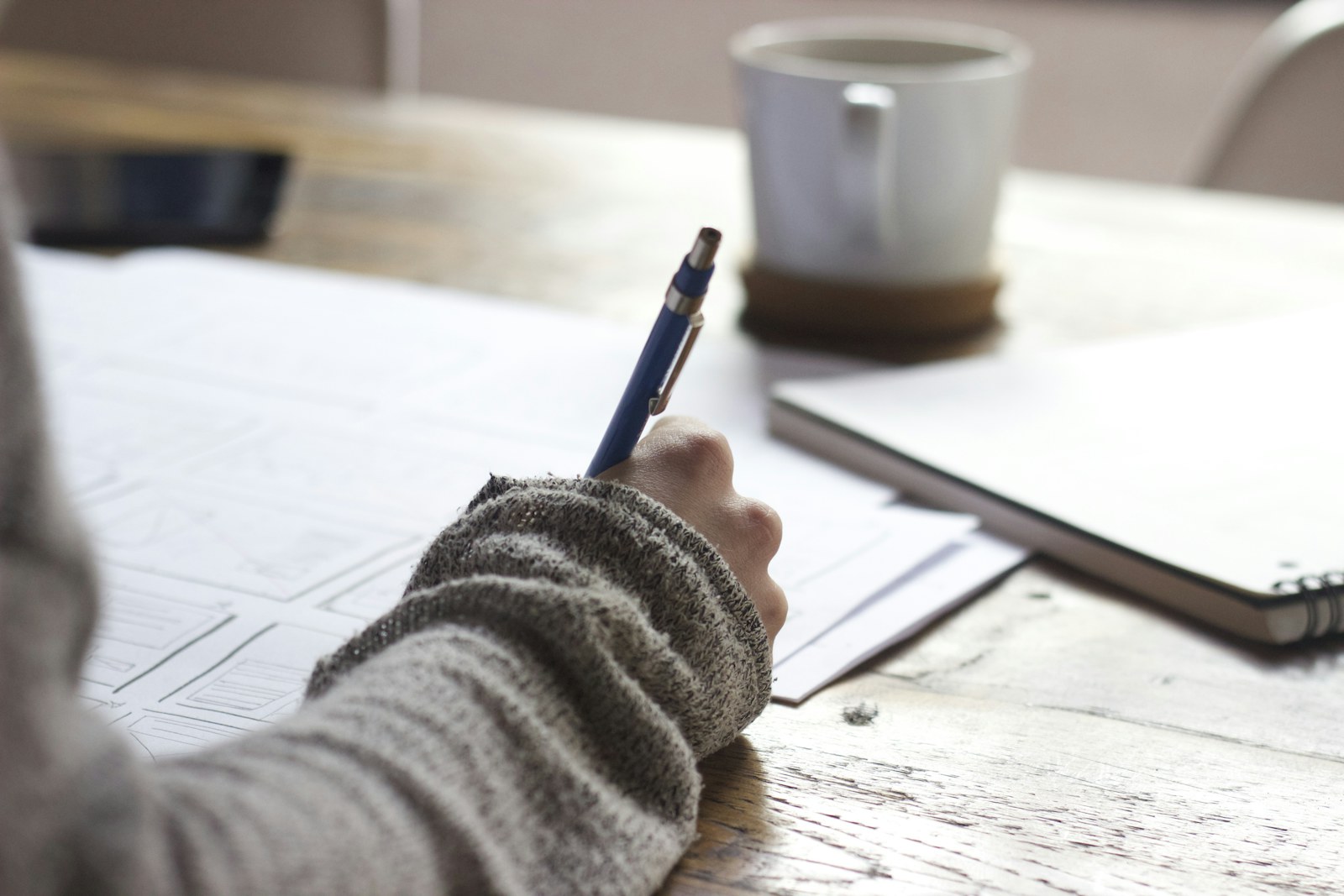 Researcher taking notes beside a source document